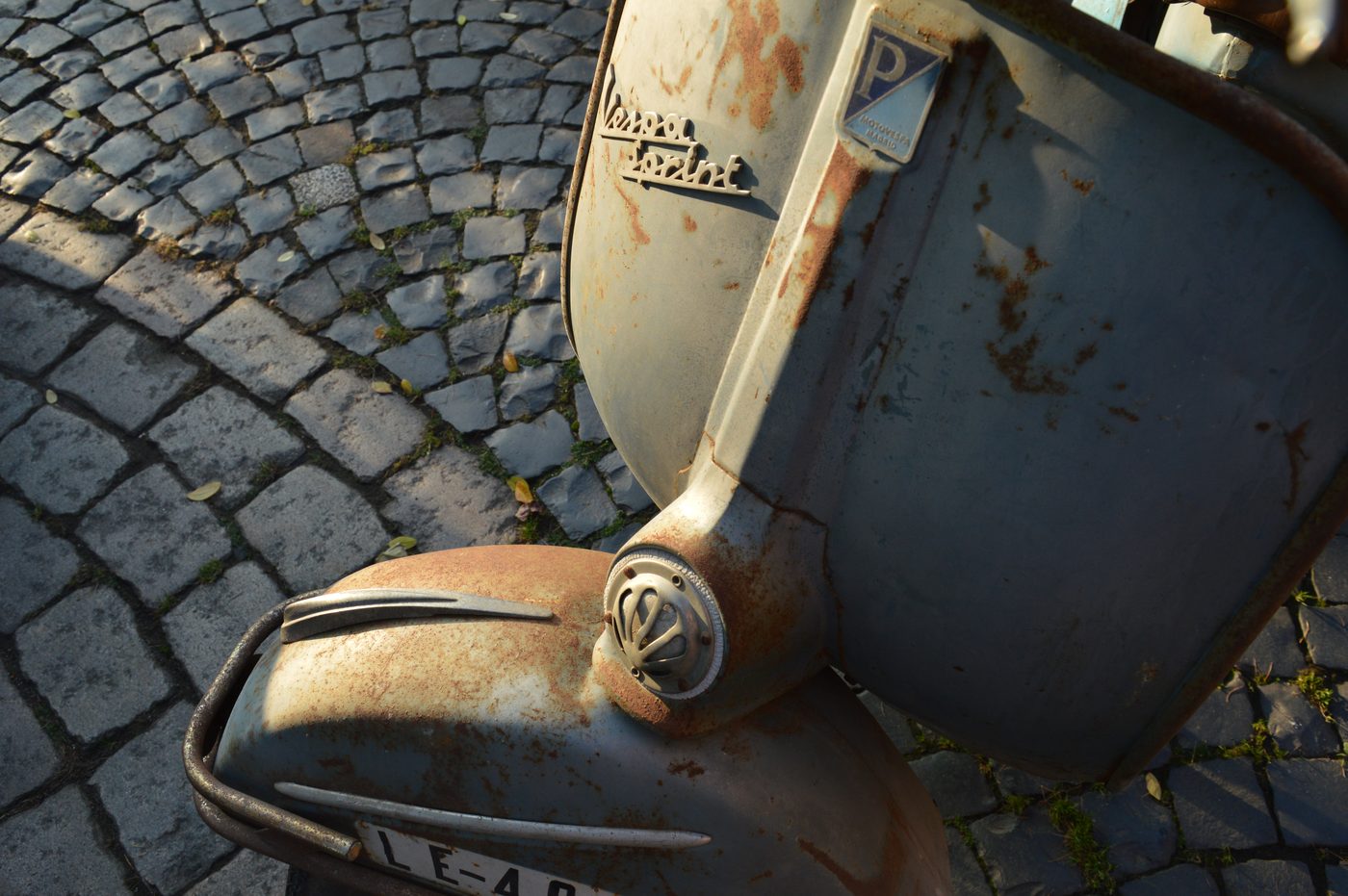 Detail einer unrestaurierten Vespa Sprint auf Kopfsteinpflaster